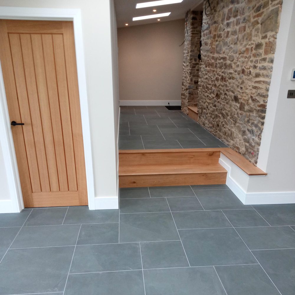 blue grey slate flooring with stone wall