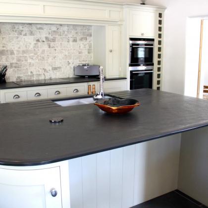 brazilian slate island top with smooth rounded edges and inset Belfast sink