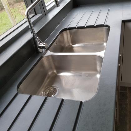 Double aspect L shaped slate surround for a metal sink