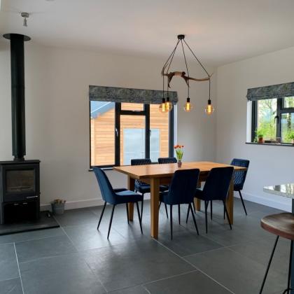 Dining room with a blue grey slate floor to woodburner