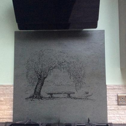 Custom engraved splashback of a tree and bench behind oven