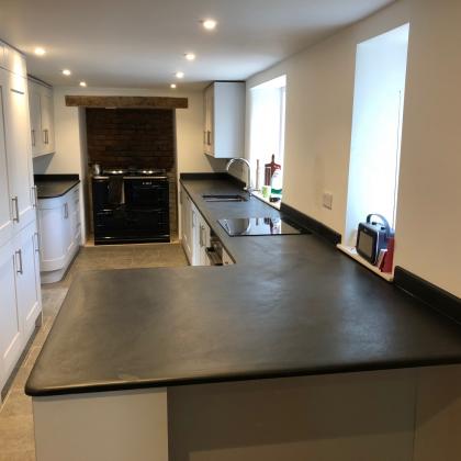 Galley style kitchen with Ardosia worktop and Aga inset oven at the end