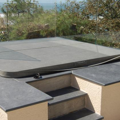 Hot tub cover in slate and surround in a garden with steps