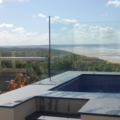 Outdoor Pool with slate copings and glass front overlooking a beach
