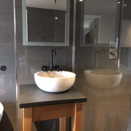 Solid natural stone sink set on a custom made slate bathroom unit