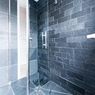 Grey slate wall tiles in a shower in a light and dark pattern