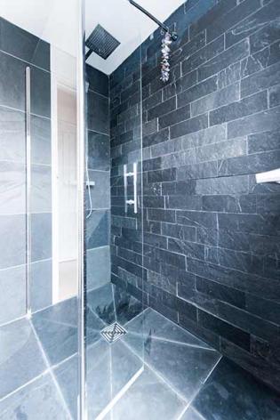 Grey slate wall tiles in a shower in a light and dark pattern