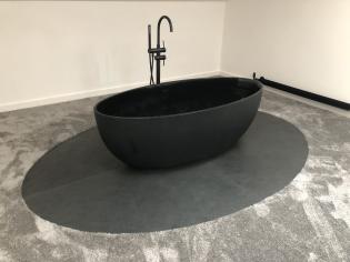 Oval bath with an oval shaped surround made in custom slate
