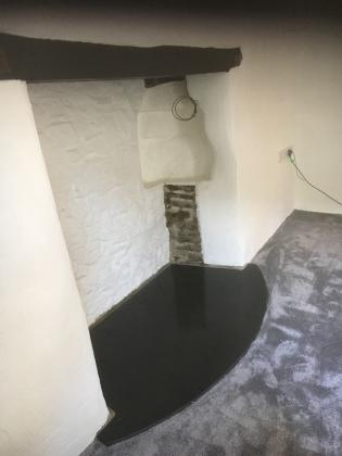 Traditional cottage inglenook with smoothed slate hearth in half moon shape