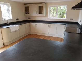 Wrap around kitchen worktop in custom made slate and grey units with under unit lighting