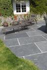 Patio in cottage garden with large rectangular slate flagstones
