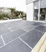 Slate flagstones in a patio below French doors, hard wearing with a rough finish.