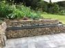patio slabs in slate with bench and stone backing in a country garden